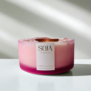 Pink candle with a SOJA Fragrances label on a white background