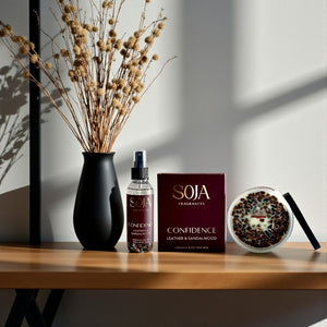 SOJA Fragrances Confidence candle and room spray on a wooden surface with decorative elements.