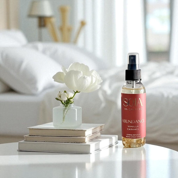 SOJA Abundance vanilla caramel room spray on a table with books and a flower