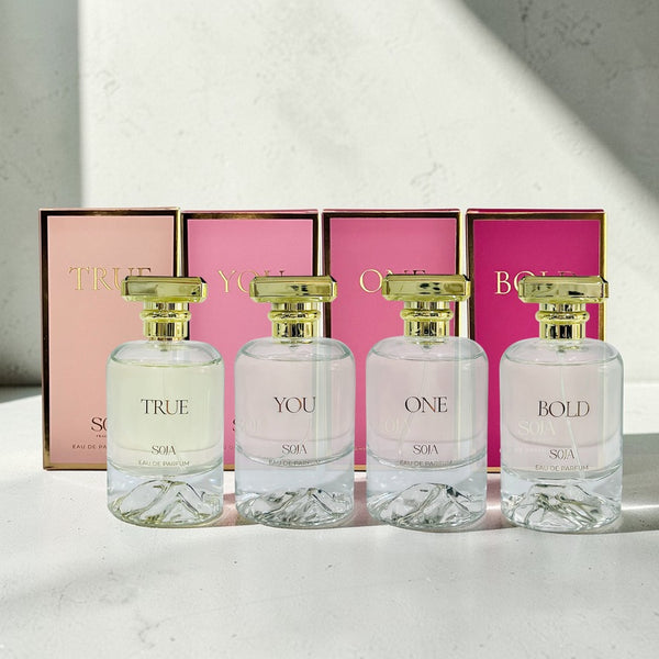 Four Soja perfume bottles with their respective boxes on a light surface.