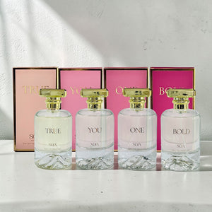 Four perfume bottles labeled 'True', 'You', 'One', and 'Bold' with matching boxes in the background.