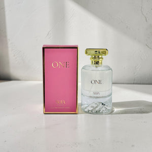 Perfume bottle and packaging with 'ONE' branding on a light surface.