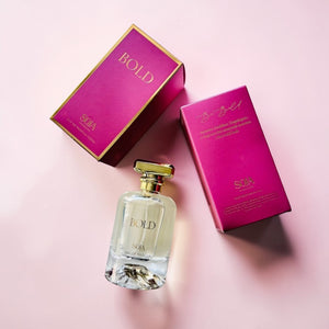 Perfume bottle and packaging with 'BOLD' branding on a pink background