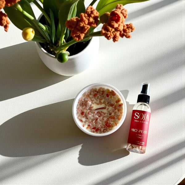 Soja candle and room spray on a white table with flowers in a white vase