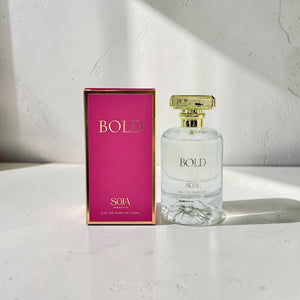 Perfume bottle and packaging with 'BOLD' branding on a light surface.