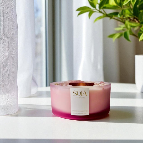Pink luxury candle on white counter with flowers
