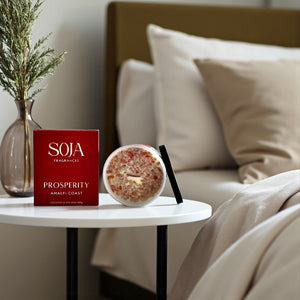 Orange SOJA Fragrances box and candle on a table with a beige sofa in the background
