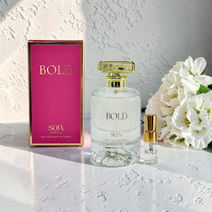 SOJA Bold perfume bottle and packaging on a white surface with flowers.
