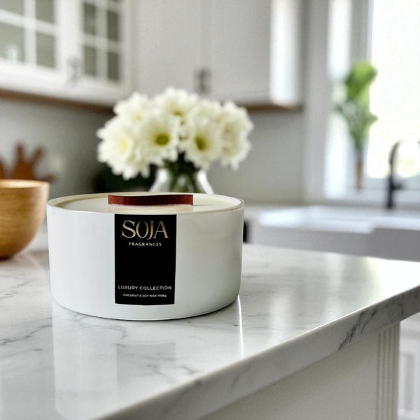 White candle with 'SOJA' label on a kitchen counter