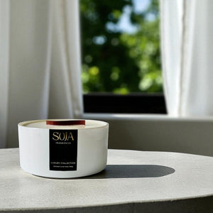 White candle bowl with a black label on a marble surface