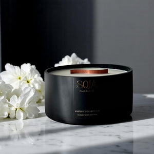Black Soja candle on marble top with white flowers
