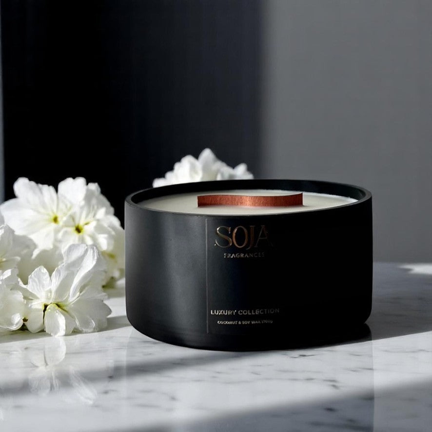 Black Soja candle on marble top with white flowers