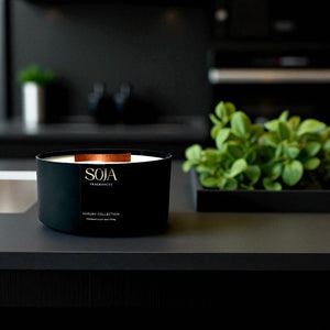 Black SOJA Fragrances candle on a kitchen counter with blurred background