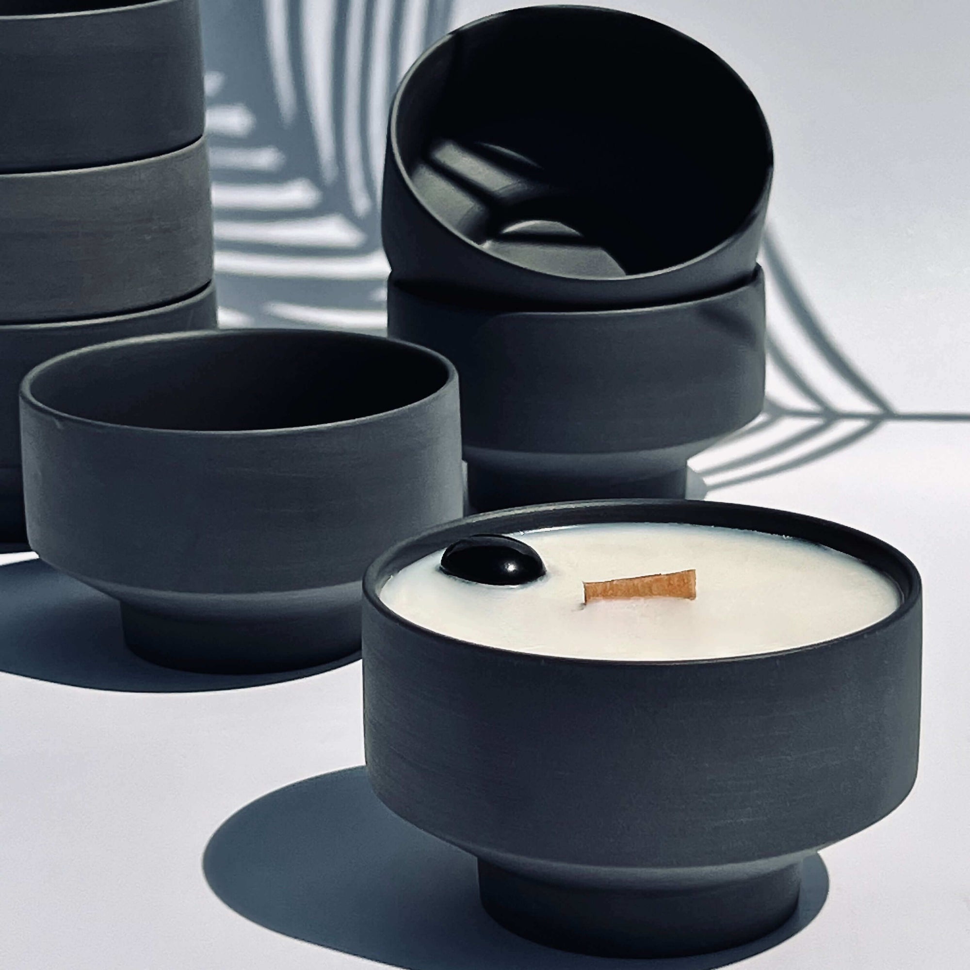 sea salt and driftwood perfumed fragranced candle with empty vessels stacked in the back ground